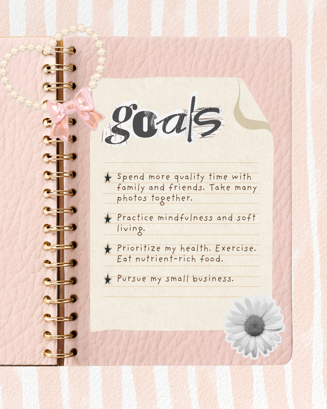 Pink notebook with a decorative paper sheet titled 'goals' on a pink and white striped background.